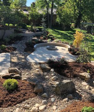 A finished custom fire pit and patio in a beautiful nature setting.