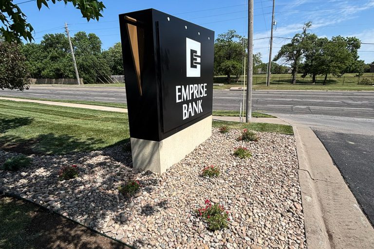 Emprise Bank signage surrounded by a landscaped bed with rocks and plants.