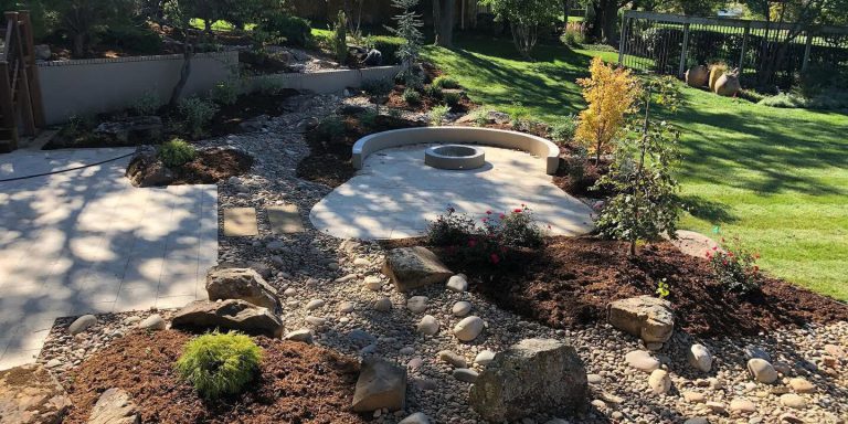 A stone fire pit with landscaping.