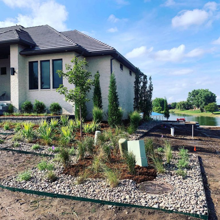 A front yard with hardscape rocks and native grasses.