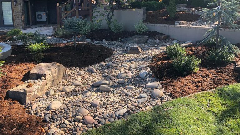 A well landscaped garden including mulch, rocks and bushes.