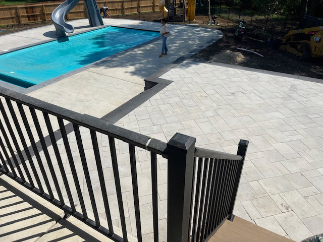 A concrete hardscape surrounds a pool.