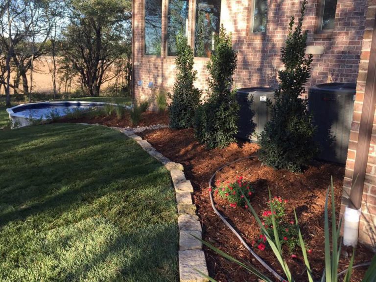 Landscaping in front of a brick home. Peak green season.