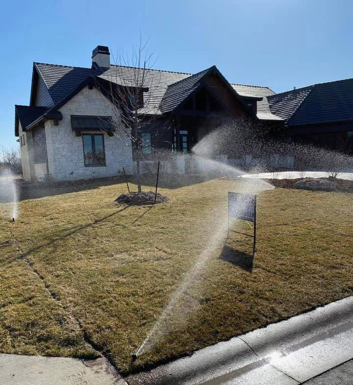 A home with a sprinkler system waters freshly installed sod.
